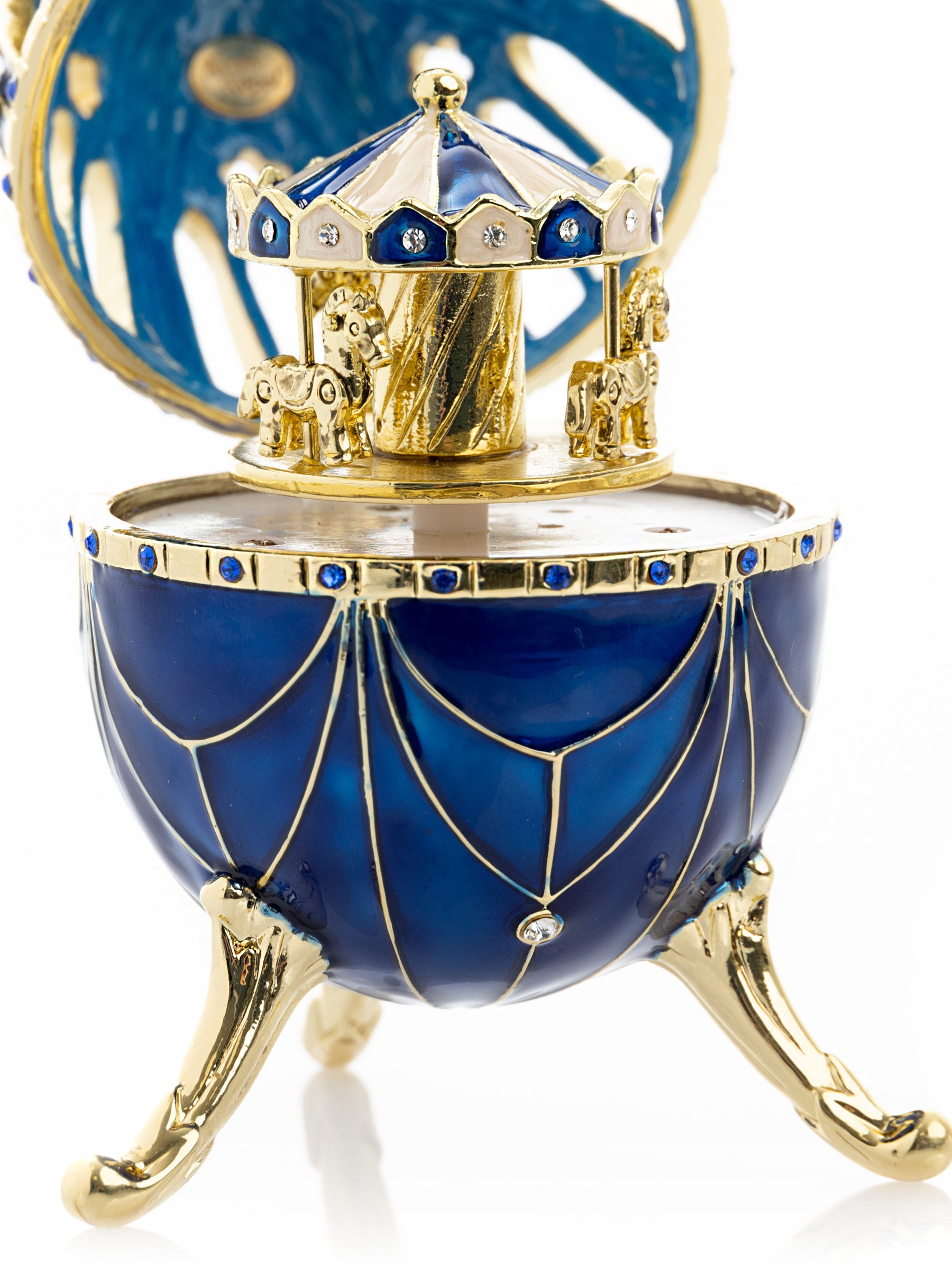 Oeuf Fabergé bleu et or avec surprise de carrousel à chevaux à l'intérieur