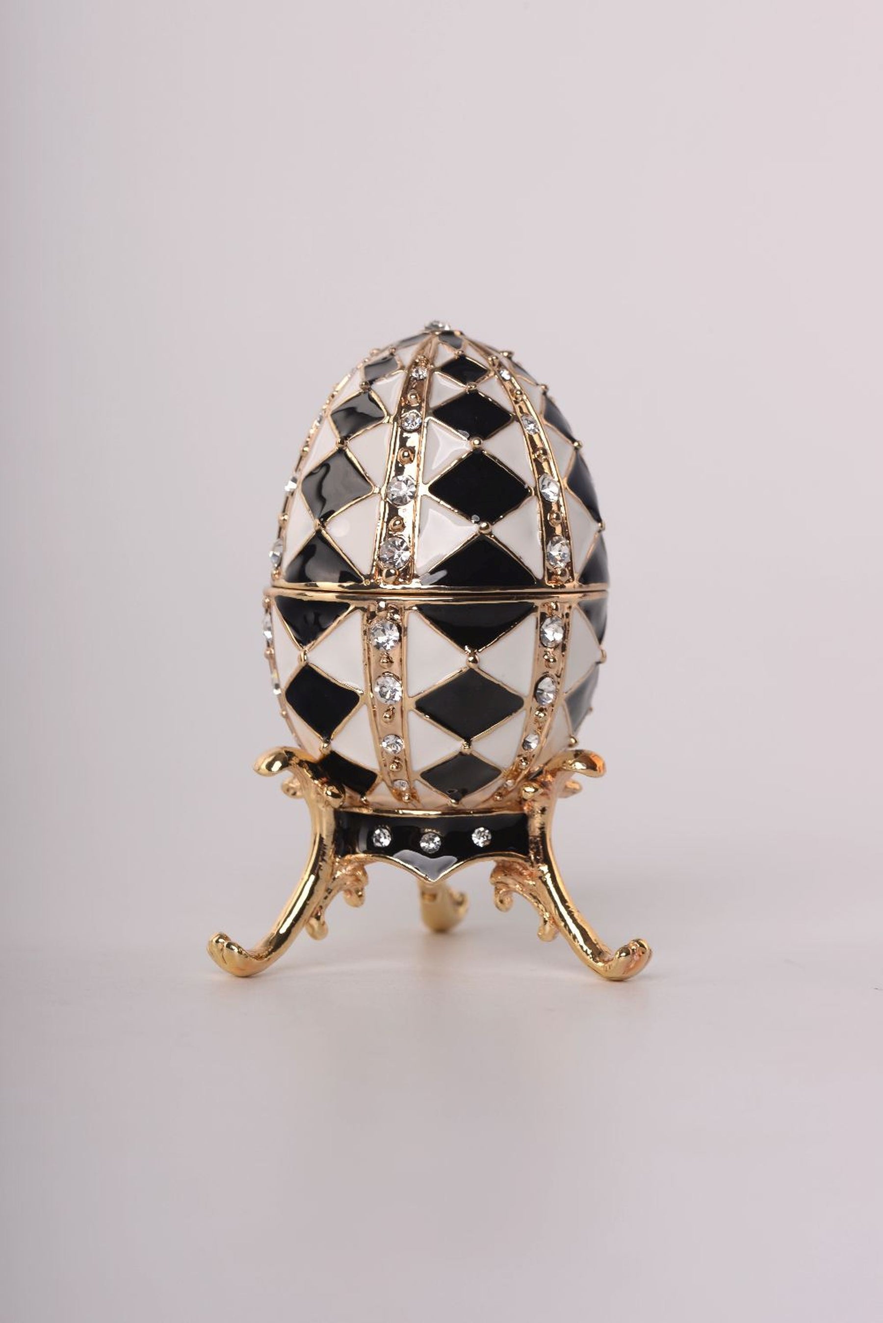 Schwarz-weißes Fabergé-Ei mit goldener Halskette im Inneren