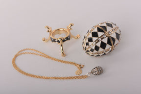 Schwarz-weißes Fabergé-Ei mit goldener Halskette im Inneren