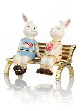2 bunnies in love sitting on a bench, valentine flowers and chocolates